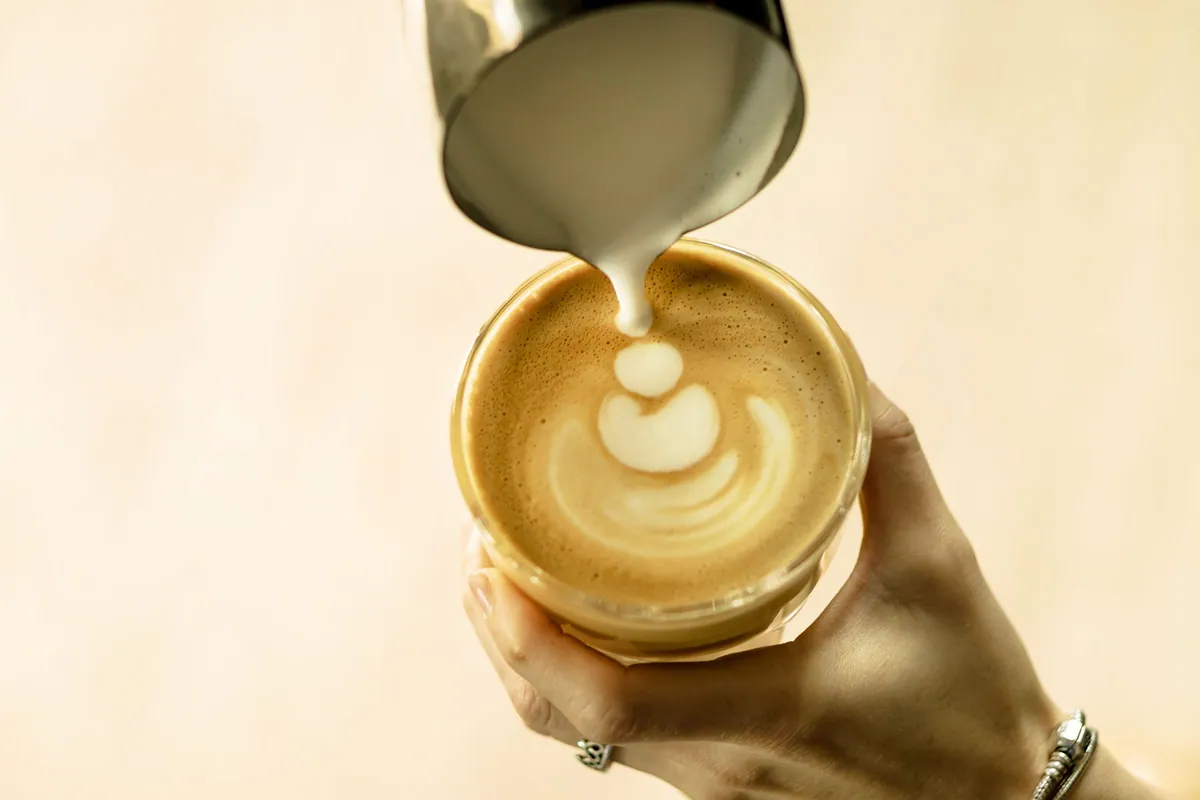 Milk being poured into a latte to make latte art